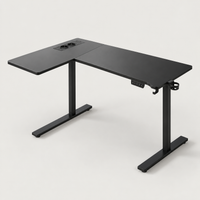 Bureau d'angle assis-debout 160 x 120 cm noir avec prises intégrées, vue de trois quarts sur fond gris clair