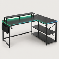 Bureau gaming d'angle compact noir avec LED et support d'écran, vue de trois quarts sur fond gris clair