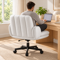 Homme assis sur la chaise extra-large blanche devant un ordinateur portable, vu de dos