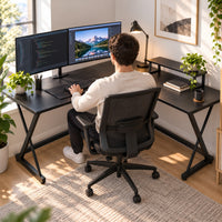 Homme travaillant au bureau d'angle en L noir, vu de dos